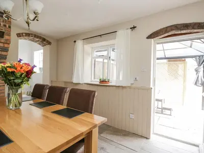 a dining room with a wooden table and chairs at The Hollies in Carlisle