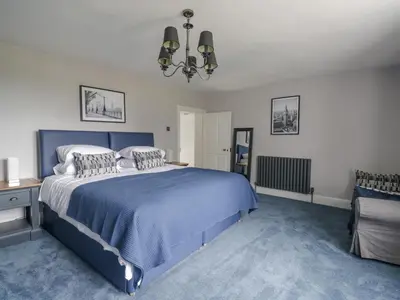 a bedroom with a blue bed with a blue carpet at The Hollies in Carlisle
