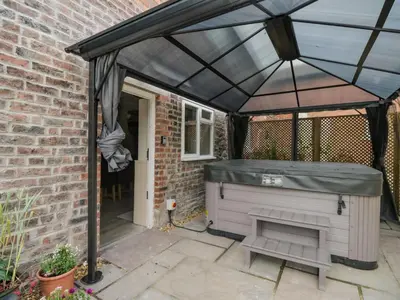 a barbecue under a black canopy in a patio at The Hollies in Carlisle