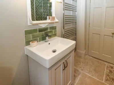 a bathroom with a white sink and a mirror at The Courtyard in Carlisle