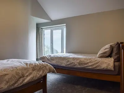 a bedroom with two beds and a window at Striding Edge Cottage in Glenridding