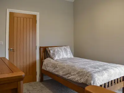 a bedroom with a bed and a wooden door at Striding Edge Cottage in Glenridding