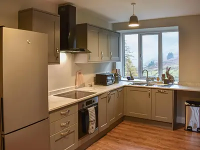 a kitchen with a refrigerator and a sink at Striding Edge Cottage in Glenridding