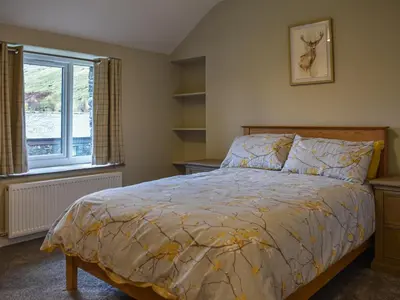 a bedroom with a bed and a window at Striding Edge Cottage in Glenridding