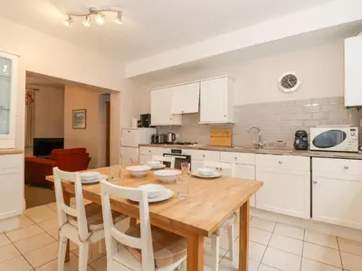 a kitchen with a wooden table and white cabinets at Riverbank in Ambleside