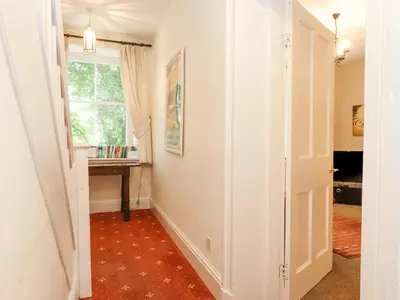 a hallway with a room with a window and a table at Riverbank in Ambleside