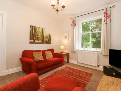 a living room with a red couch and a window at Riverbank in Ambleside