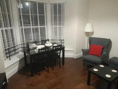 a living room with a dining room table and a chair at Kirkcudbright Holiday Apartments - Apartment D in Kirkcudbright