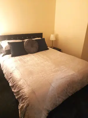 a bedroom with a large bed with pillows at Kirkcudbright Holiday Apartments - Apartment D in Kirkcudbright