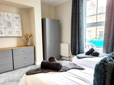a bedroom with two beds and a large window at Carvetii - ANNE House Room 1 - Dbl bed Ground floor en-suite in Carlisle