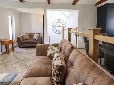 a living room with a couch and a table at Mallard Cottage Lake District, Leisure Spa Pool & Gym in Penruddock