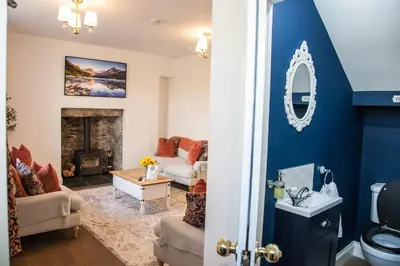a living room with blue walls and a fireplace at Stunning Scottish Hot Tub Getaway in Gatehouse of Fleet