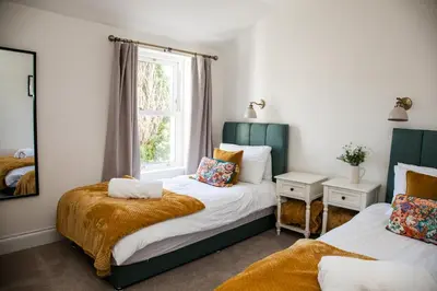a bedroom with two beds and a window at Stunning Scottish Hot Tub Getaway in Gatehouse of Fleet