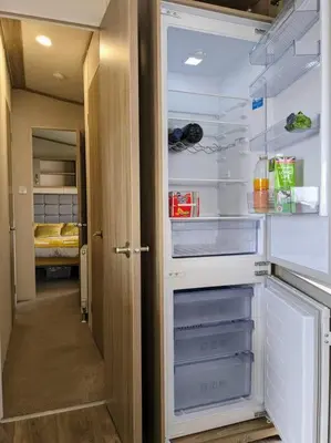 an empty refrigerator with its door open in a room at Beautiful Pet Friendly Southerness Caravan With Sea View & Decking Area in Mainsriddle