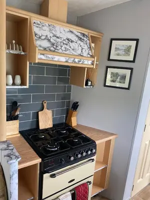 a kitchen with a stove in a small kitchen at Inglenook Caravan in Lamplugh