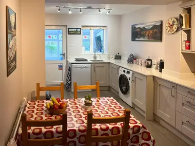 a kitchen with a table with a bowl of fruit on it at Hill Cottage, Braithwaite with garden and fell views, dog friendly walks from the door, close to Bassenthwaite in Braithwaite