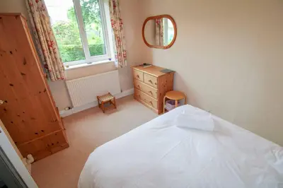 a bedroom with a bed and a dresser and a mirror at Hill Cottage, Braithwaite with garden and fell views, dog friendly walks from the door, close to Bassenthwaite in Braithwaite