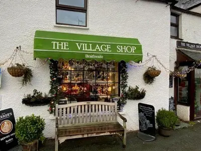 a shop with a bench in front of the village shop at Hill Cottage, Braithwaite with garden and fell views, dog friendly walks from the door, close to Bassenthwaite in Braithwaite