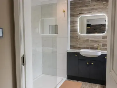 a bathroom with a sink and a shower with a mirror at Hardhills Cottage in Castle Douglas
