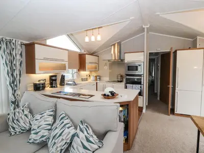 a kitchen and a living room with a couch at No 7 Skiddaw View in Cockermouth