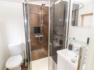 a bathroom with a shower with a toilet and a sink at No 7 Skiddaw View in Cockermouth