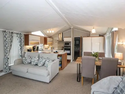 a living room and kitchen with a couch and a table at No 7 Skiddaw View in Cockermouth