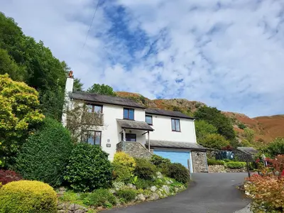 a white house with a blue garage at Spedding Fold Chapel Stile in Chapel Stile