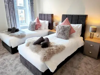 a bedroom with two beds with faux fur at Carvetii - ANNE House Room 3 - Triple bed first flr en-suite in Carlisle