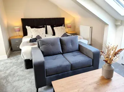 a living room with a bed and a blue couch at Carvetii - ANNE House Room 4 - Triple bed 2nd floor en-suite in Carlisle