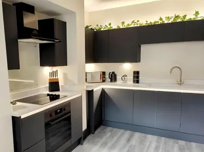 a kitchen with black and white cabinets and a sink at Carvetii - ANNE House Room 4 - Triple bed 2nd floor en-suite in Carlisle