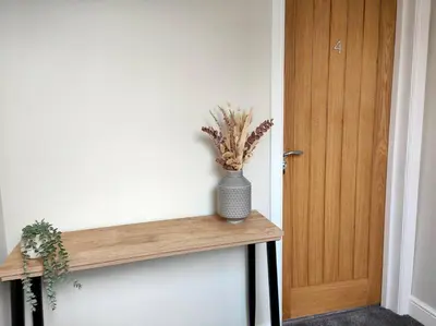 a room with a wooden door and a shelf with a plant at Carvetii - ANNE House Room 4 - Triple bed 2nd floor en-suite in Carlisle