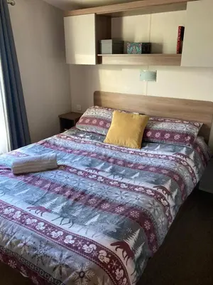 a bedroom with a bed with a colorful blanket at Lake District Solway View 16 The Beeches Caravan Park in Gilcrux