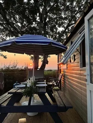 a patio with an umbrella and chairs on a deck at Lake District Solway View 16 The Beeches Caravan Park in Gilcrux