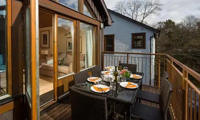 a table on the balcony of a house at Keswick Bridge Lodge Resort in Keswick