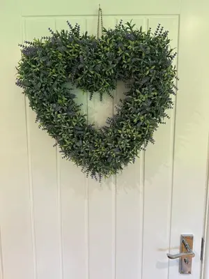 a green wreath hanging on a white door at Oak View Lodge: Cosy, Countryside Retreat in Maybole