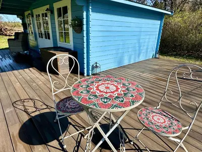 a table and two chairs on a deck at Oak View Lodge: Cosy, Countryside Retreat in Maybole
