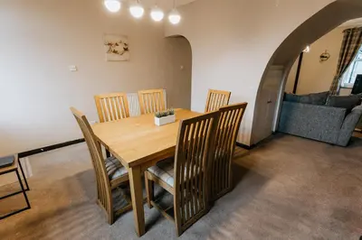 a dining room with a wooden table and chairs at Winnie's Cottage - 3 Bed Accommodation in Cumbria in Mealsgate