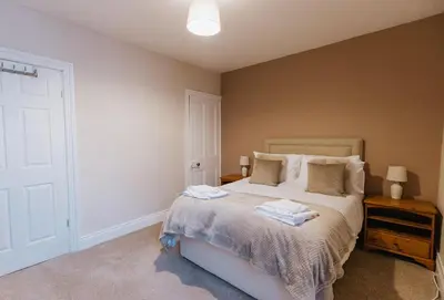 a bedroom with a bed with two towels on it at Winnie's Cottage - 3 Bed Accommodation in Cumbria in Mealsgate