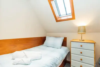 a small bedroom with a bed and a dresser at Valley View at Clauchan Holiday Cottages in Gatehouse of Fleet