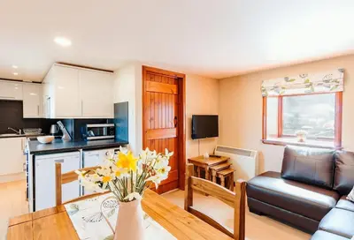 a kitchen and living room with a couch and a table at Valley View at Clauchan Holiday Cottages in Gatehouse of Fleet