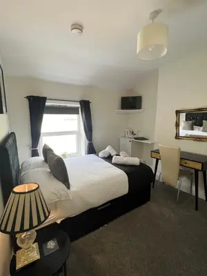 a bedroom with a bed and a desk and a desk at Elizabeth Grace House in Douglas