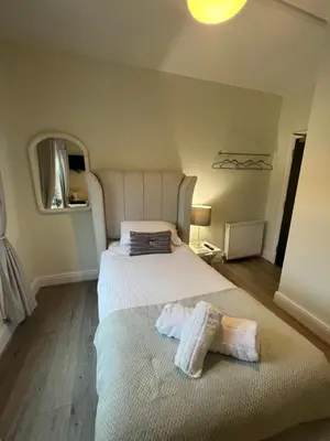 a bedroom with a bed with two towels on it at Elizabeth Grace House in Douglas