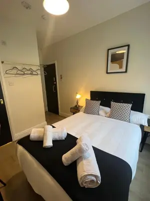 a bedroom with a large bed with towels on it at Elizabeth Grace House in Douglas