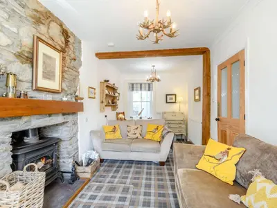 a living room with a couch and a fireplace at Priory Walk in Newton Stewart