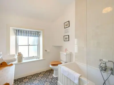 a bathroom with a toilet and a tub and a sink at Priory Walk in Newton Stewart