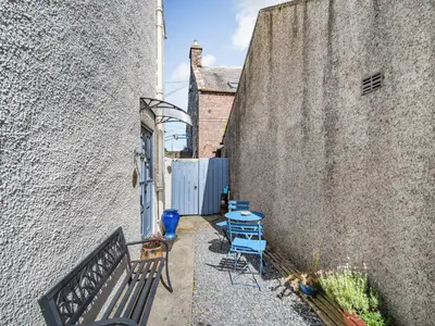 a small alley with a bench and a table at Priory Walk in Newton Stewart