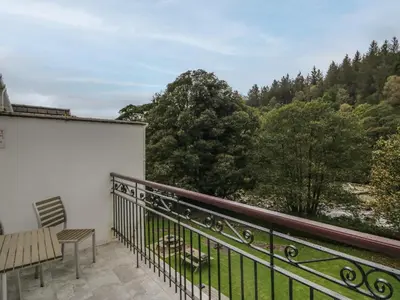a balcony with a bench and a view of trees at Apartment 4 in Keswick