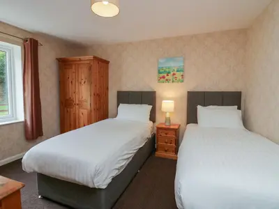a bedroom with two beds and a window at Apartment 4 in Keswick