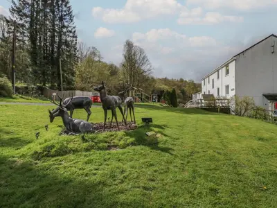 a group of deer statues in a grassy field at Apartment 4 in Keswick