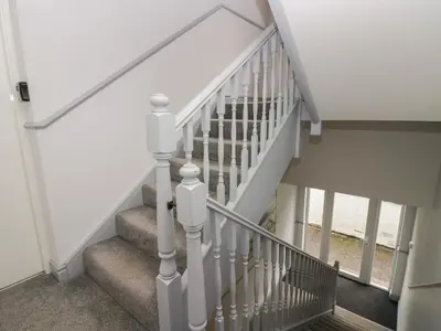 a staircase with white railings in a house at Apartment 6 in Keswick
